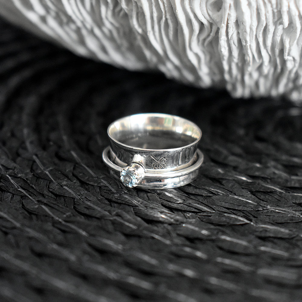 Catalina dandelion etched spinner ring with blue topaz